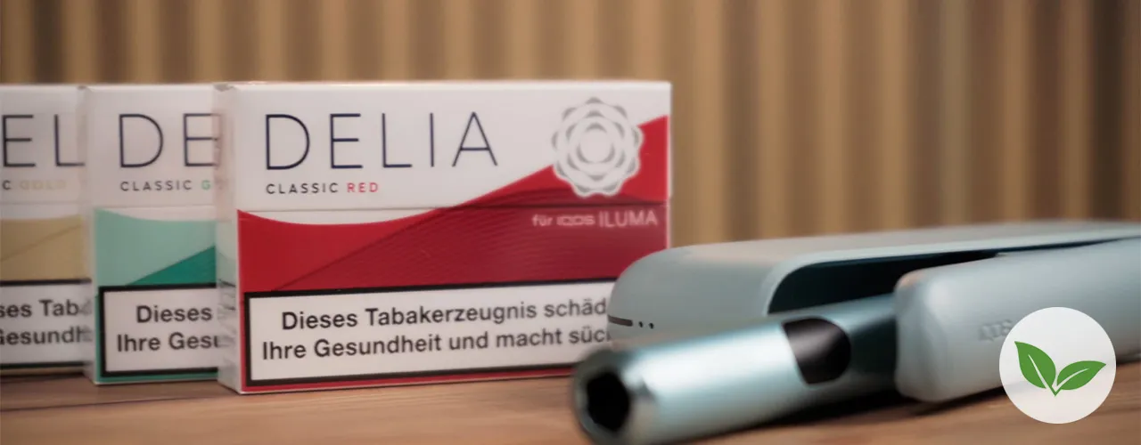 Produkte der Marke IQOS: ILUMA I KIT und DELIA Sticks auf einem Tisch liegend